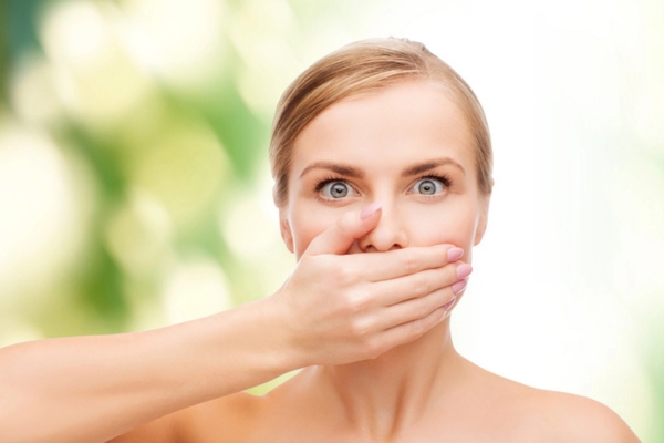 shocked woman covering nose depicting gas smell detection at home