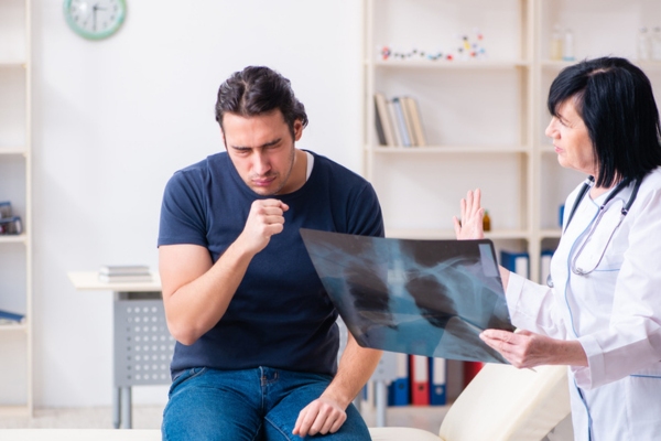 doctor showing xray film to man coughing depicting risks of mold at home