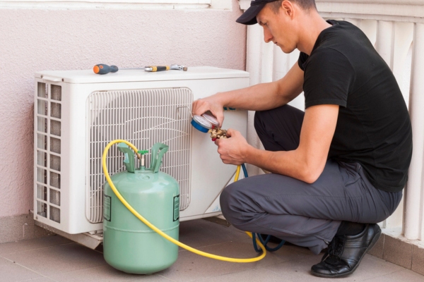 HVAC technician inspecting refrigerant level depicting refrigerant absorbing the heat from indoors and air conditioning system