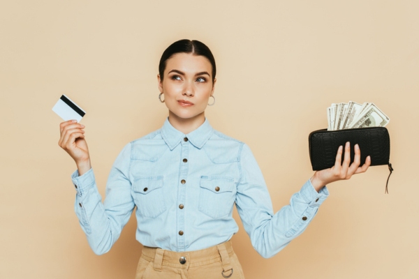 woman holding wallet with cash and credit card on each hands depicting higher price tag of double-wall oil tank