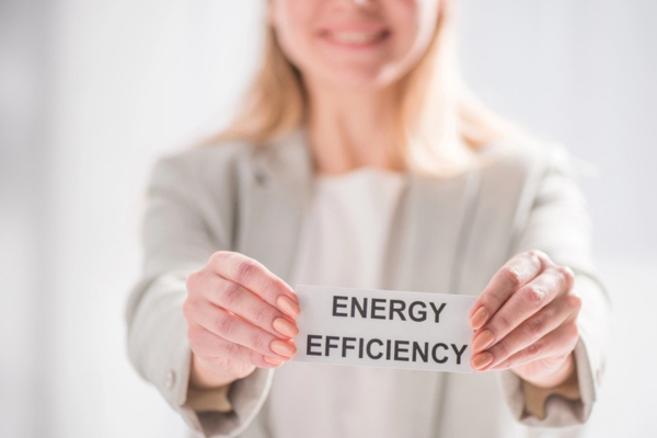 woman smiling while holding energy efficiency note depicting tips for cooking with propane