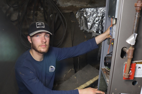 Lake Region Energy HVAC technician inspecting home HVAC system