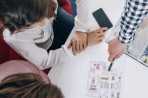 Top view of couple in real-estate agency looking at a model of a potential house