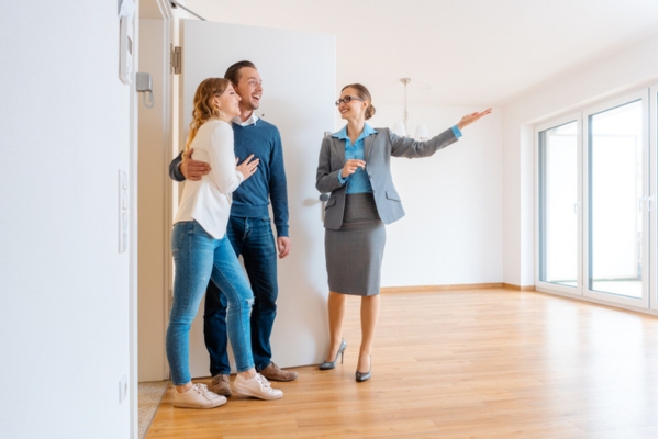 realtor showing the bedroom to a couple looking for a new home