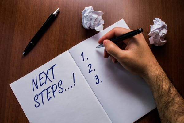 man writing next steps on notebook depicting steps to enhance heater efficiency