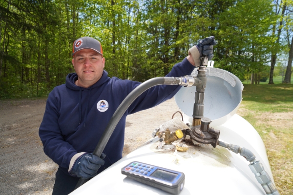 Lake Region Energy professional staff inspecting and refilling client's home propane tank