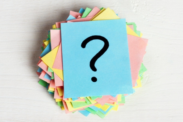 Question mark on a stack of colored papers depicting FAQs for winter maintenance