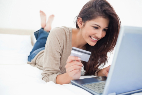 woman on her laptop holding a credit card depicting automatic oil delivery