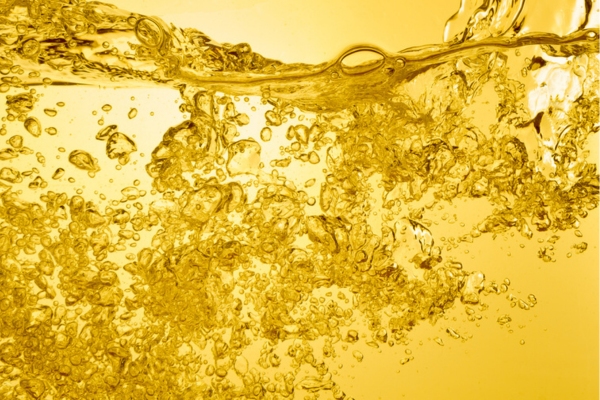 bubbles on gold liquid depicting gelling of heating oil