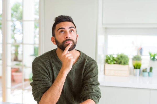 man looking up while thinking depicting selecting an ideal replacement boiler